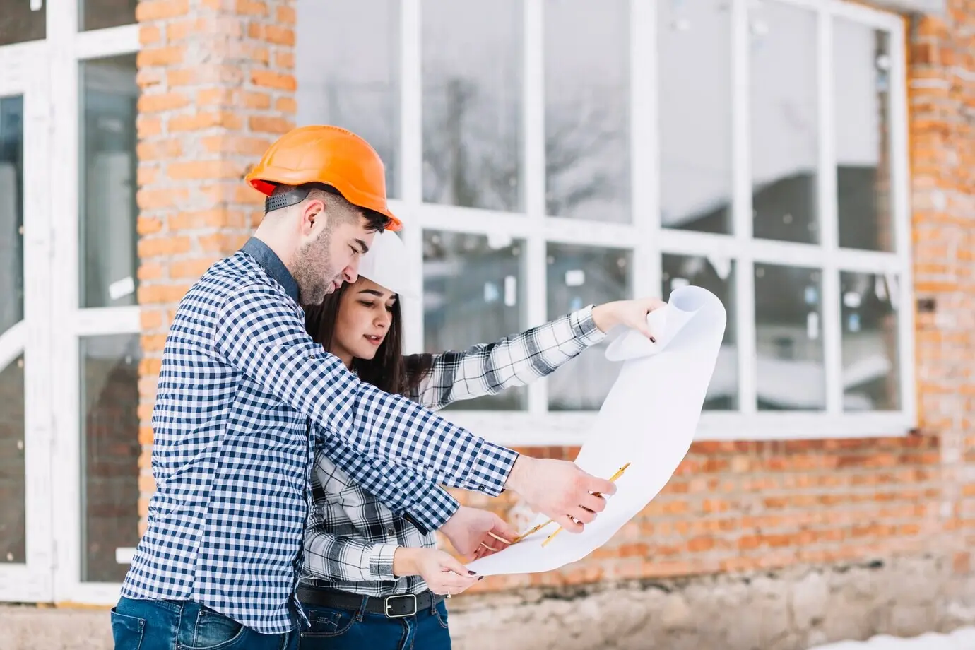 Architects reviewing a plan in front of a house